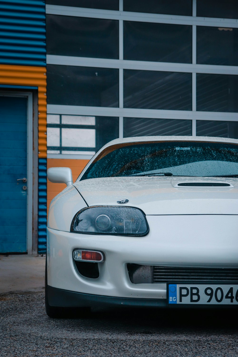 a white sports car parked in front of a building