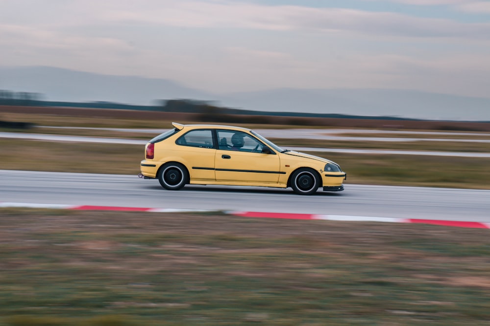 a yellow car driving down a race track