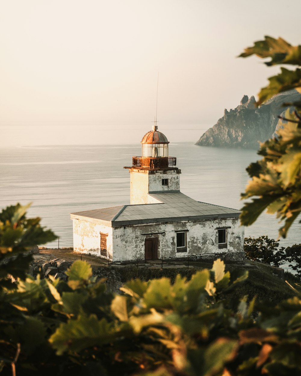 a white building with a brown roof near the ocean