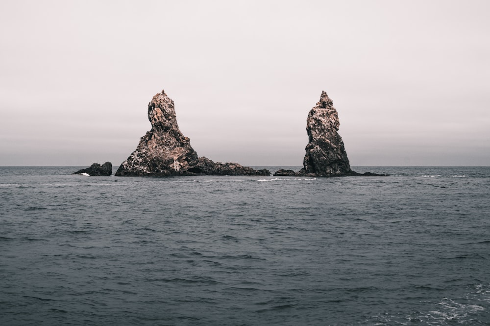 two large rocks sticking out of the ocean