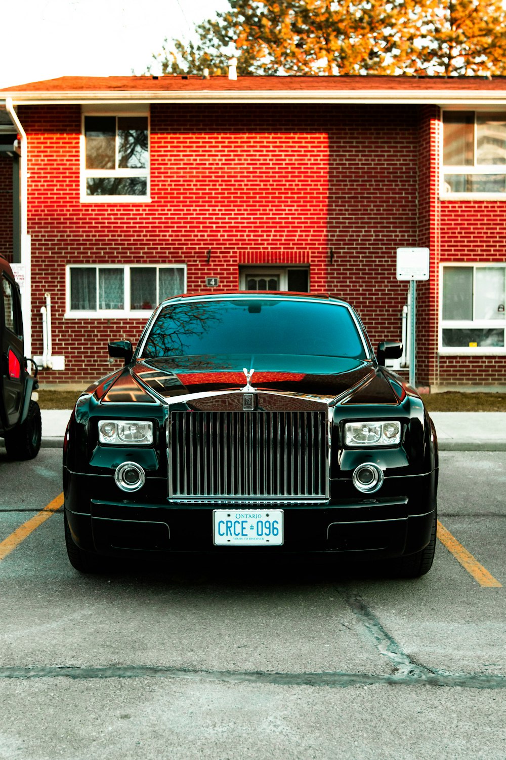 a rolls royce parked in front of a red brick building