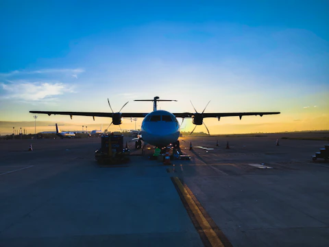 A Beechcraft Baron taxiing on a runway at sunset, ready for repositioning.
