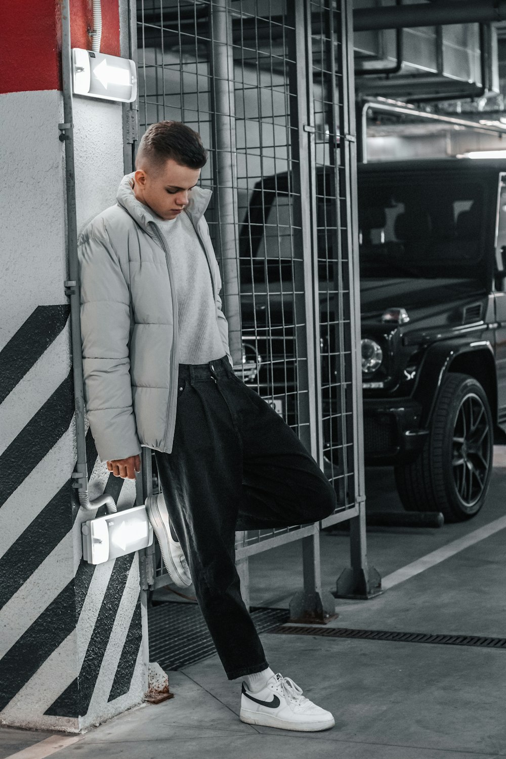 a man leaning against a wall in a garage