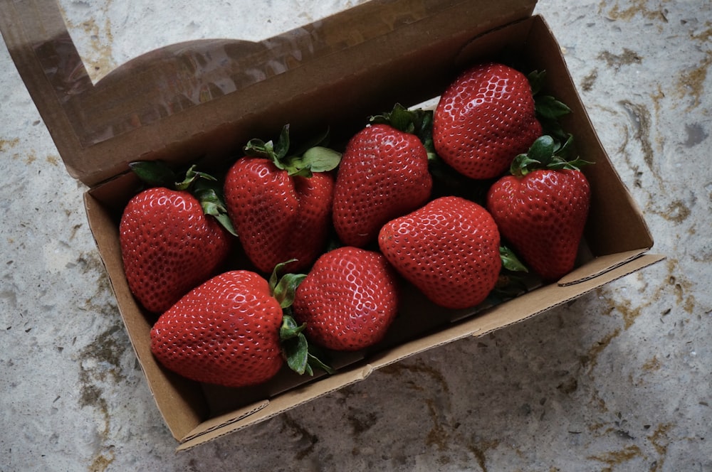 a box filled with lots of ripe strawberries