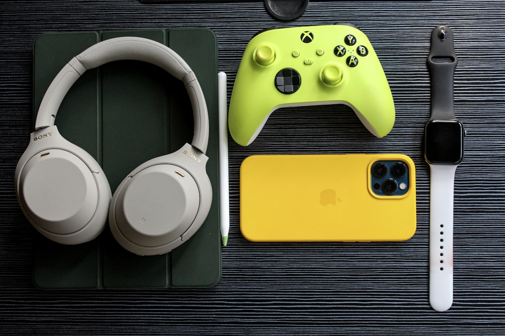 a pair of headphones, a yellow iphone case, and a pair of head