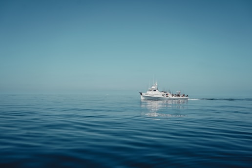 a white boat floating on top of a large body of water