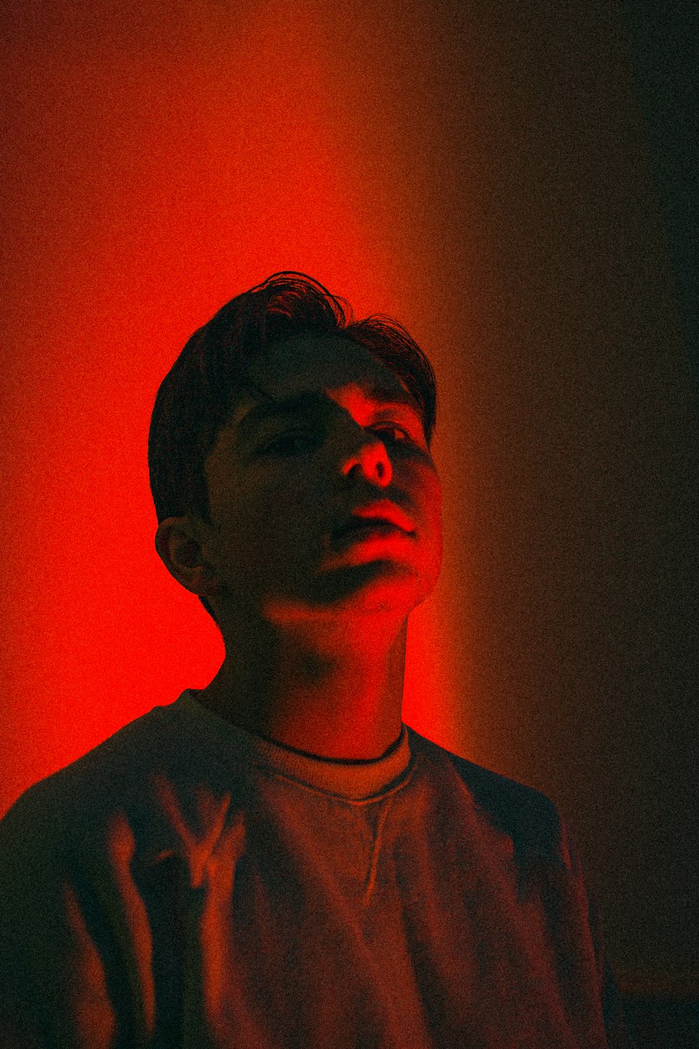 a young man in a dark room with a red light