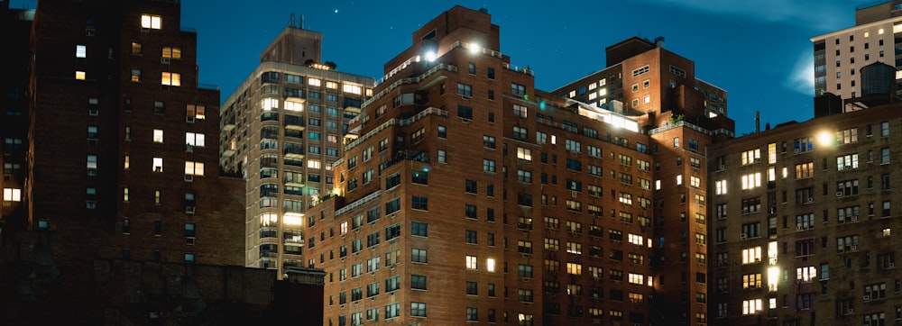 a group of tall buildings lit up at night