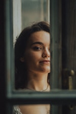 A woman visualizing her goals in a peaceful room filled with soft light.