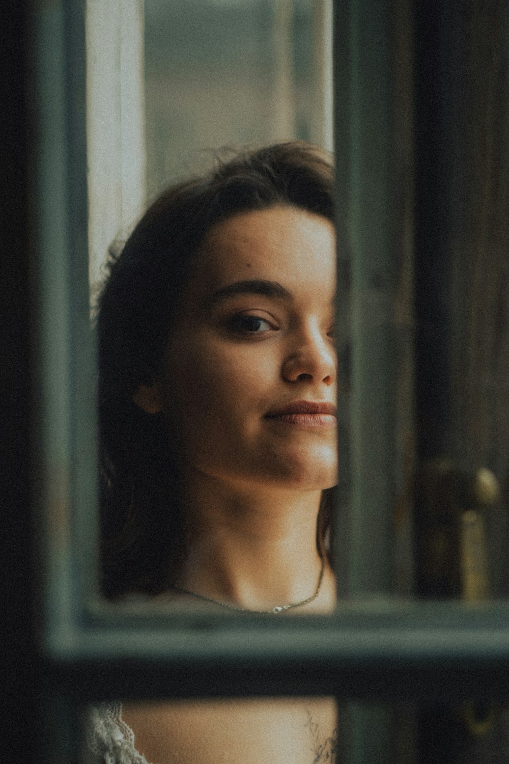 a woman looking out of a window at something