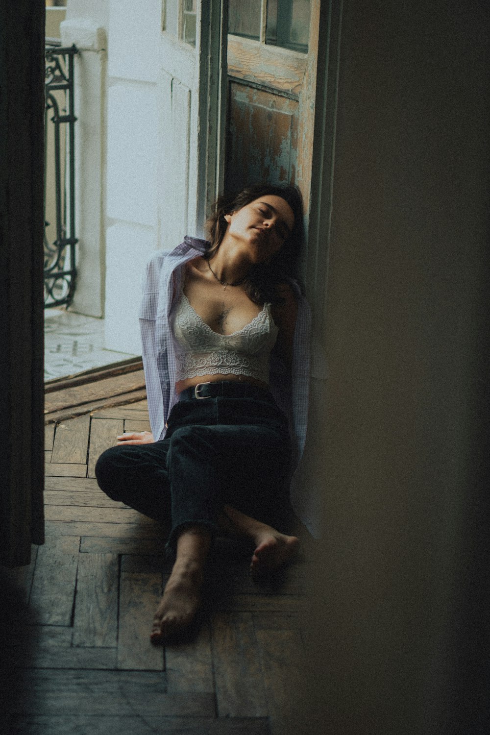 a woman sitting on the floor in front of a door