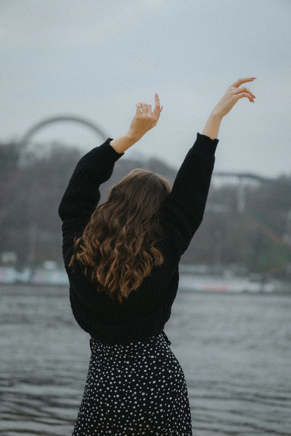 a woman standing in front of a body of water