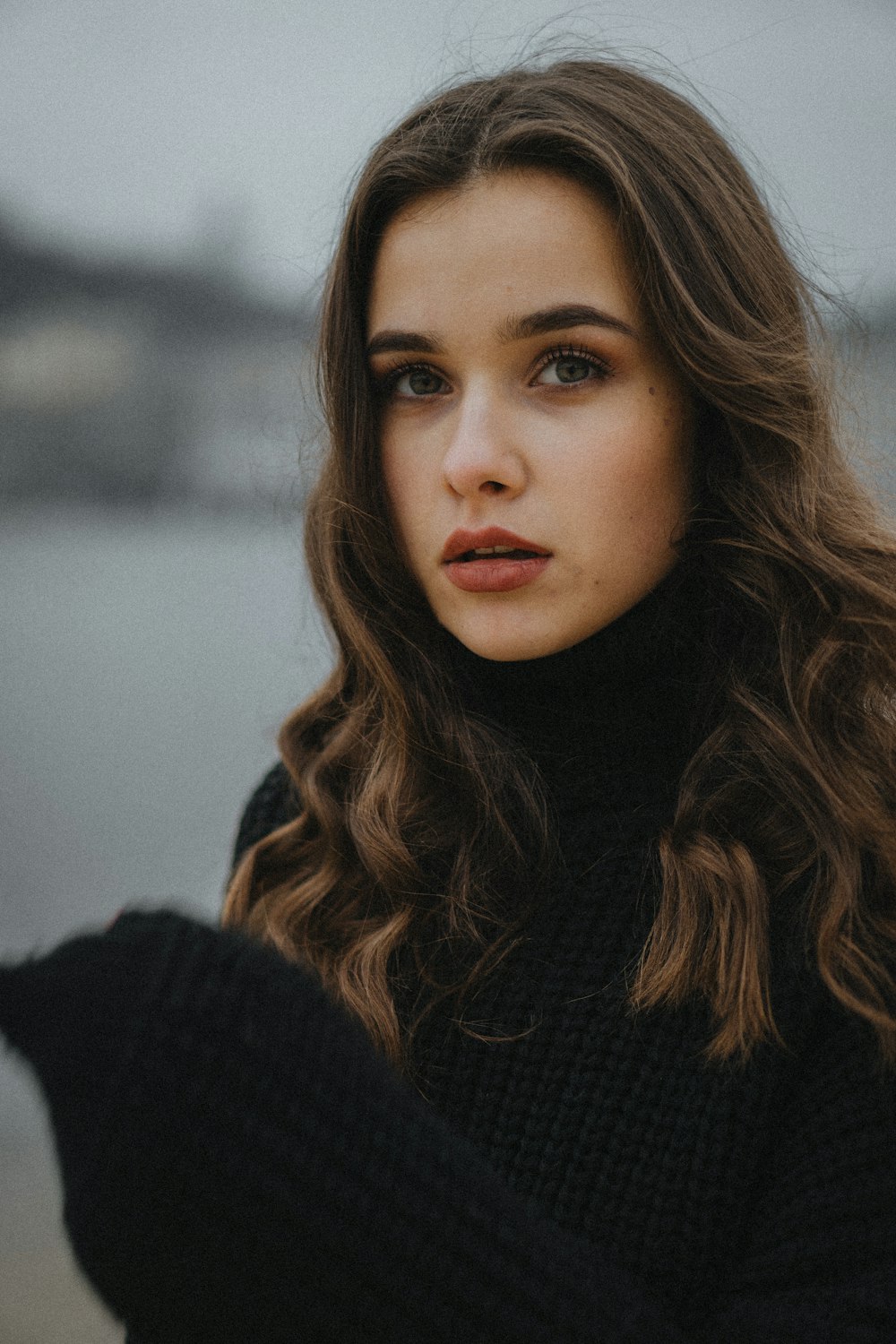 a woman with long hair wearing a black sweater