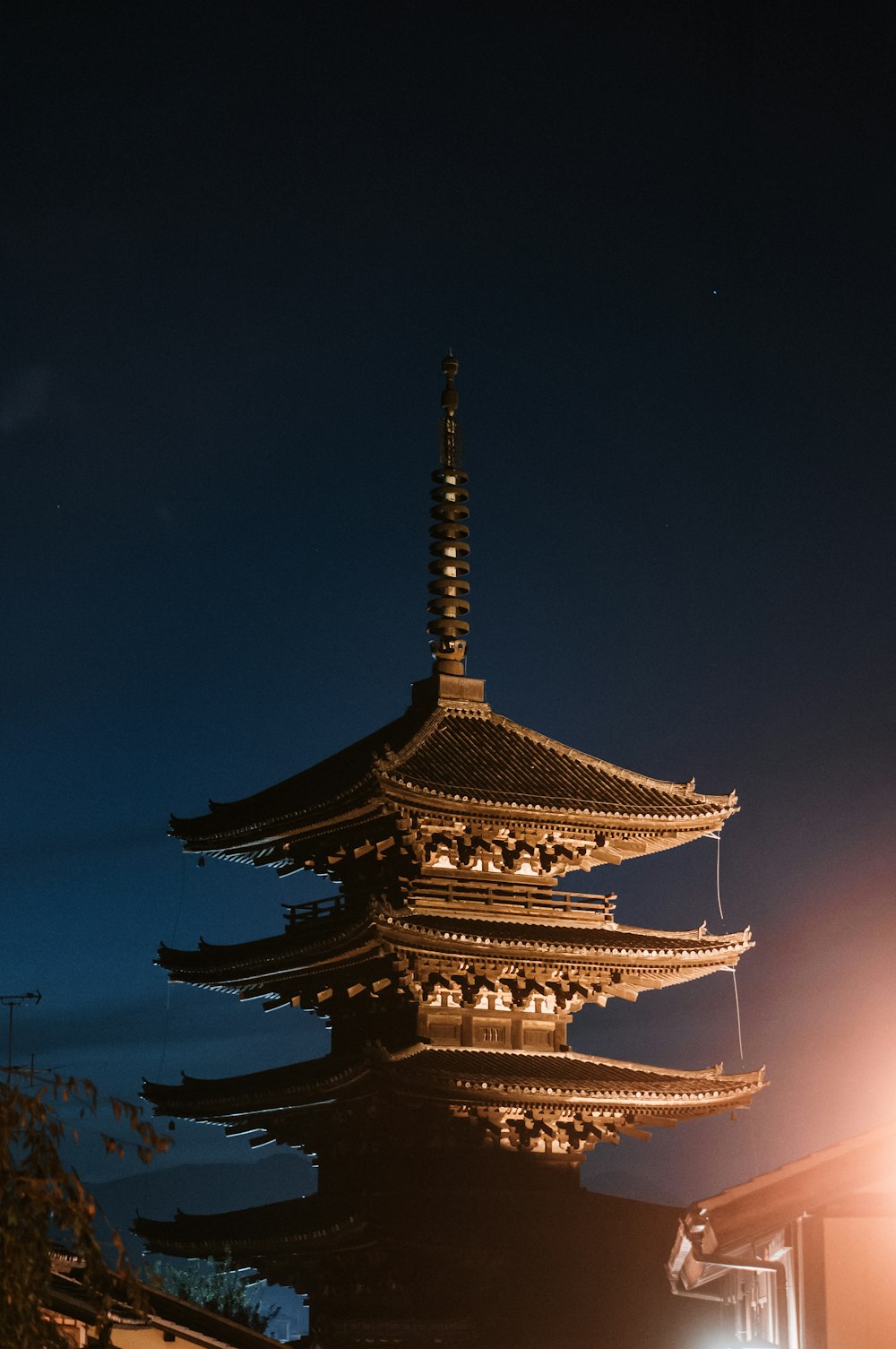 a tall building lit up at night with a sky background