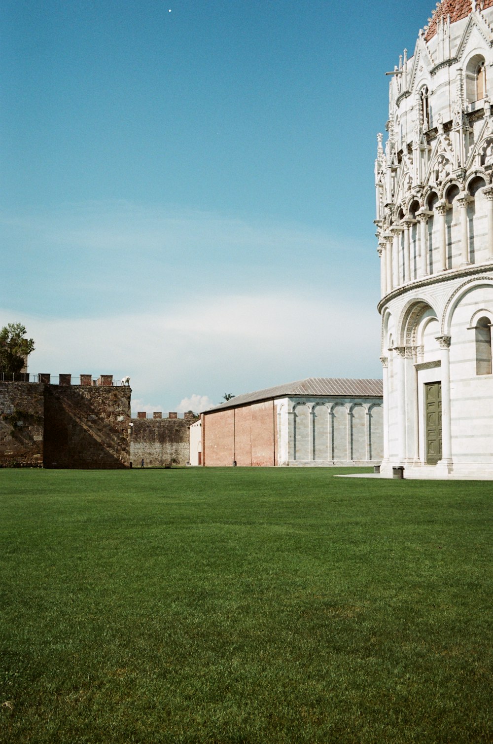 a large white building sitting on top of a lush green field