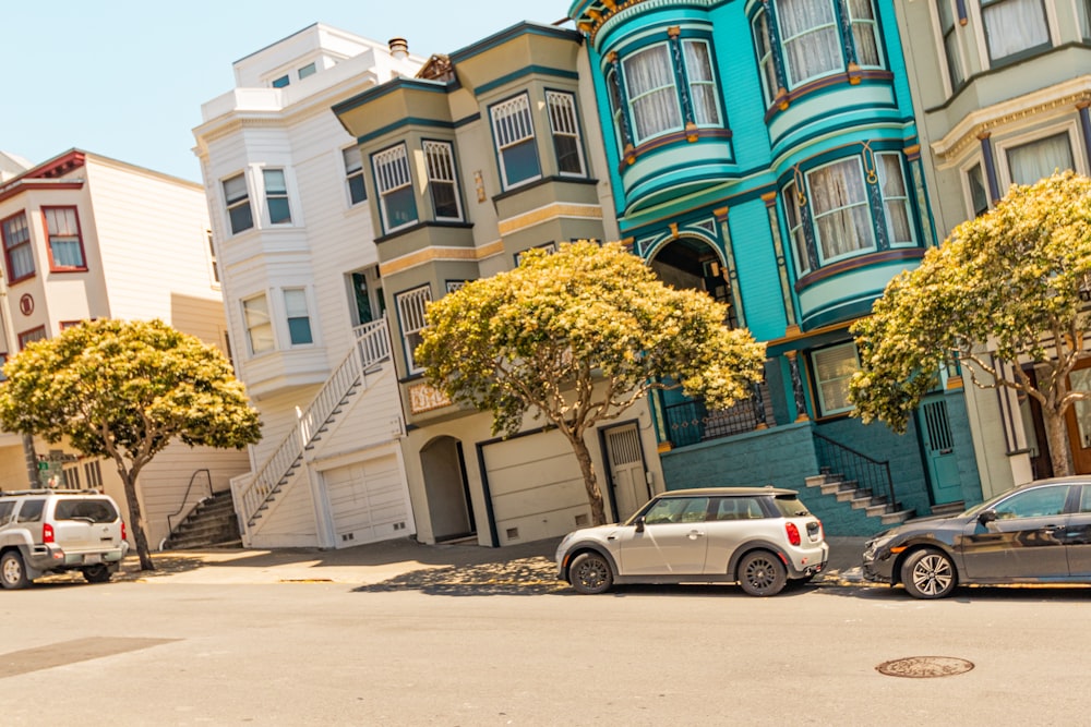 a group of cars parked in front of a row of houses