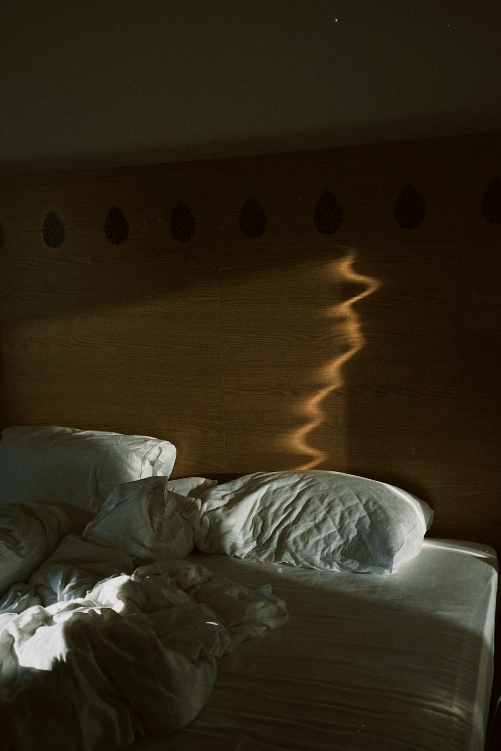 a bed with white sheets and a wooden headboard