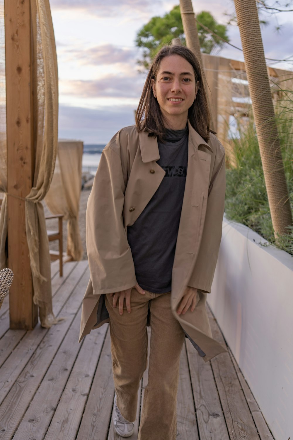 a woman is standing on a wooden deck