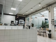 Open kitchen with sleek lines, terracotta walls, and green plants enhancing the modern minimalist style.