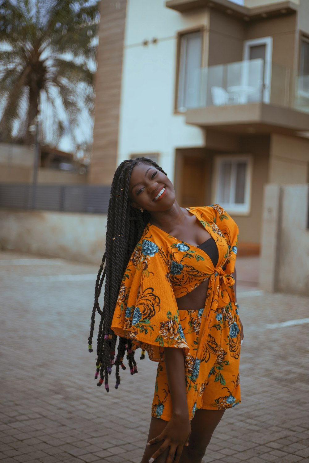 a woman with dreadlocks standing in front of a building