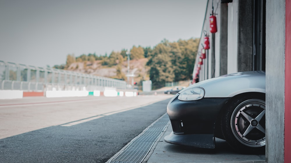 a car parked on the side of a road next to a building