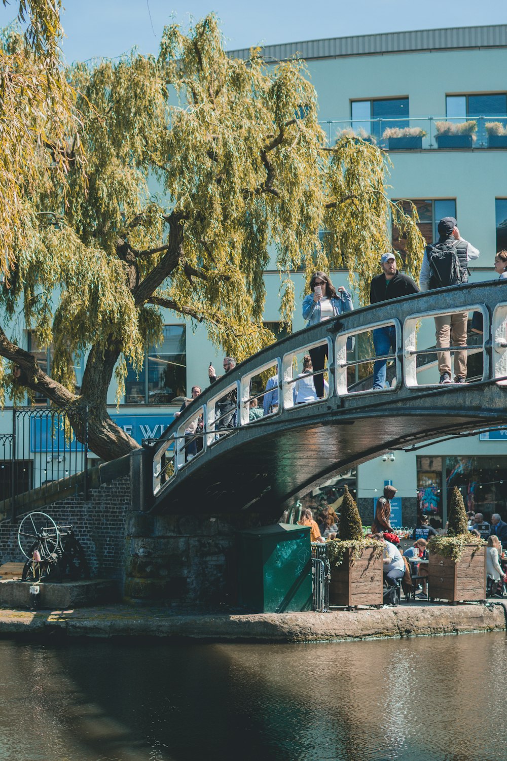 um grupo de pessoas de pé em uma ponte sobre um rio