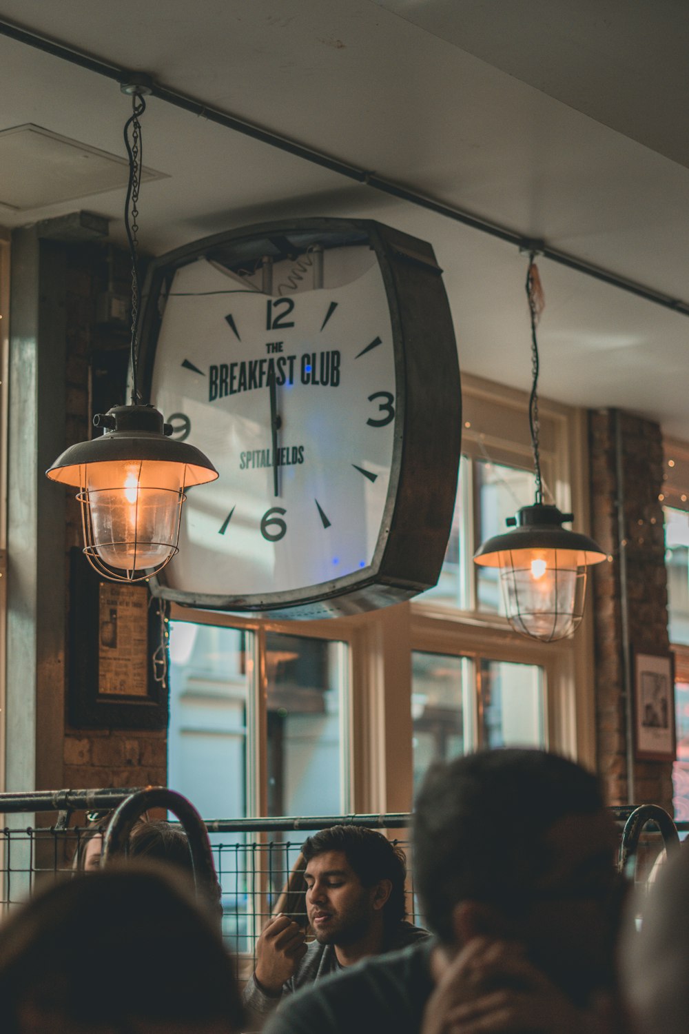 a clock hanging from the ceiling of a restaurant