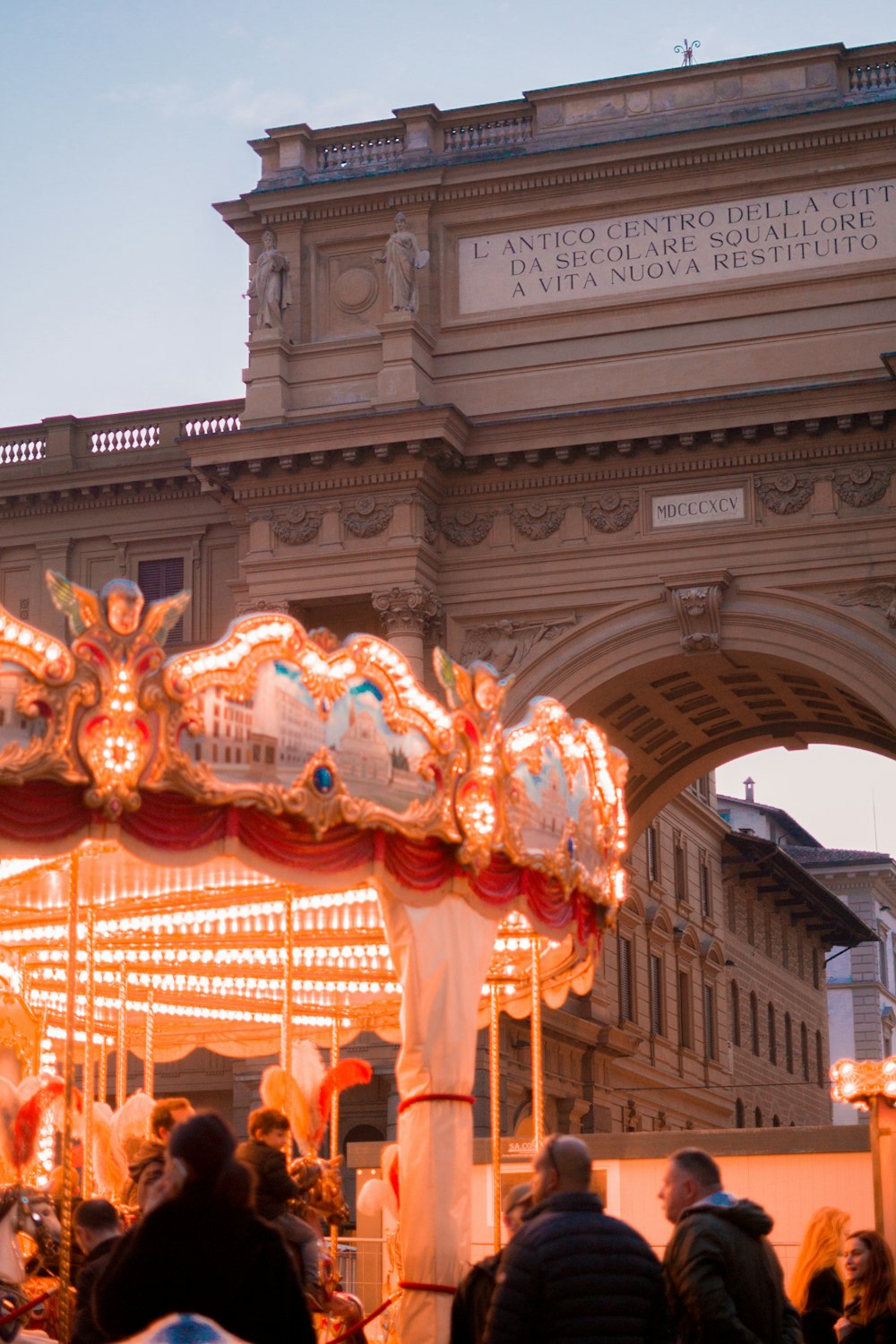 a group of people standing around a merry go round