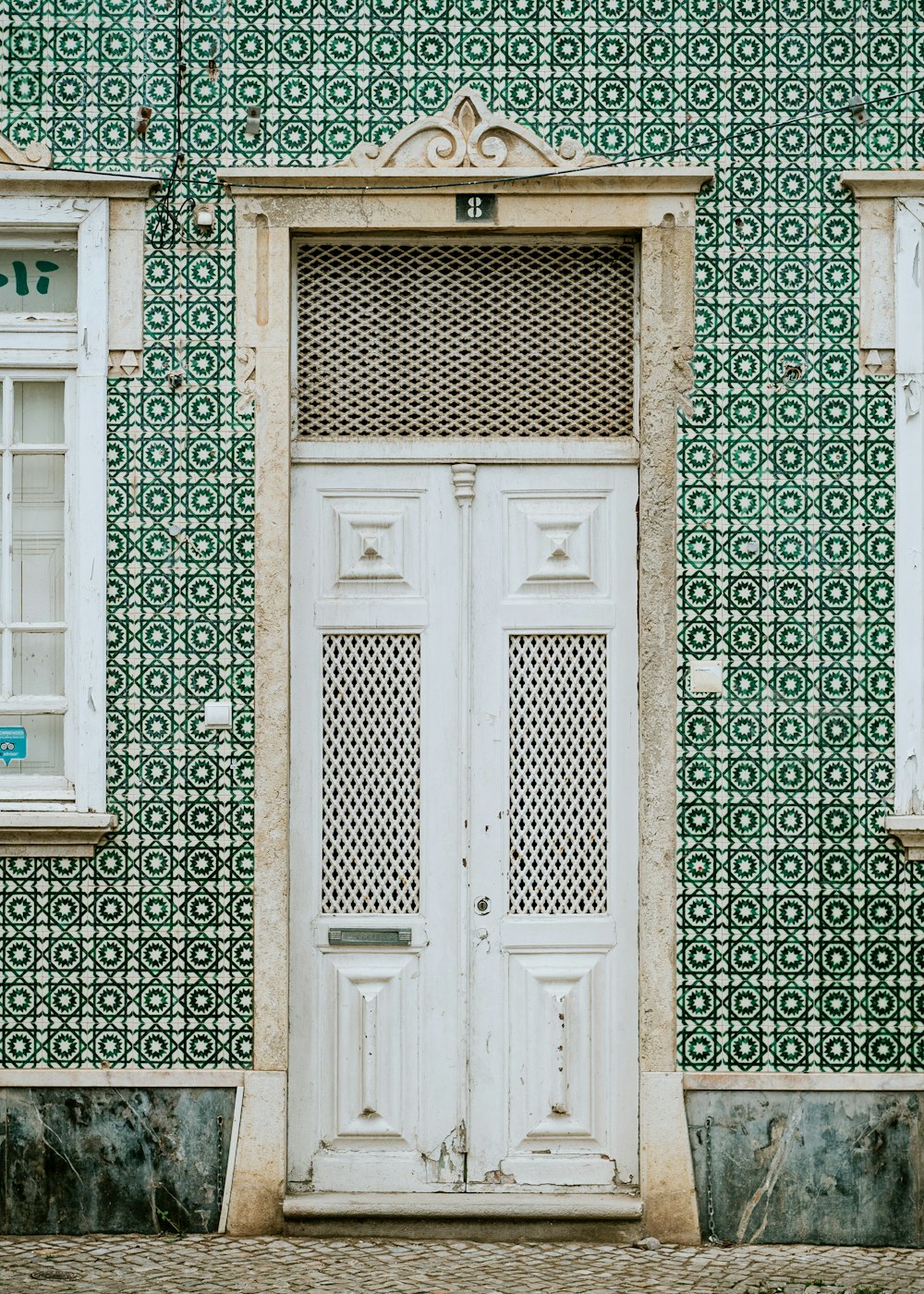 a white door sitting in front of a green wall