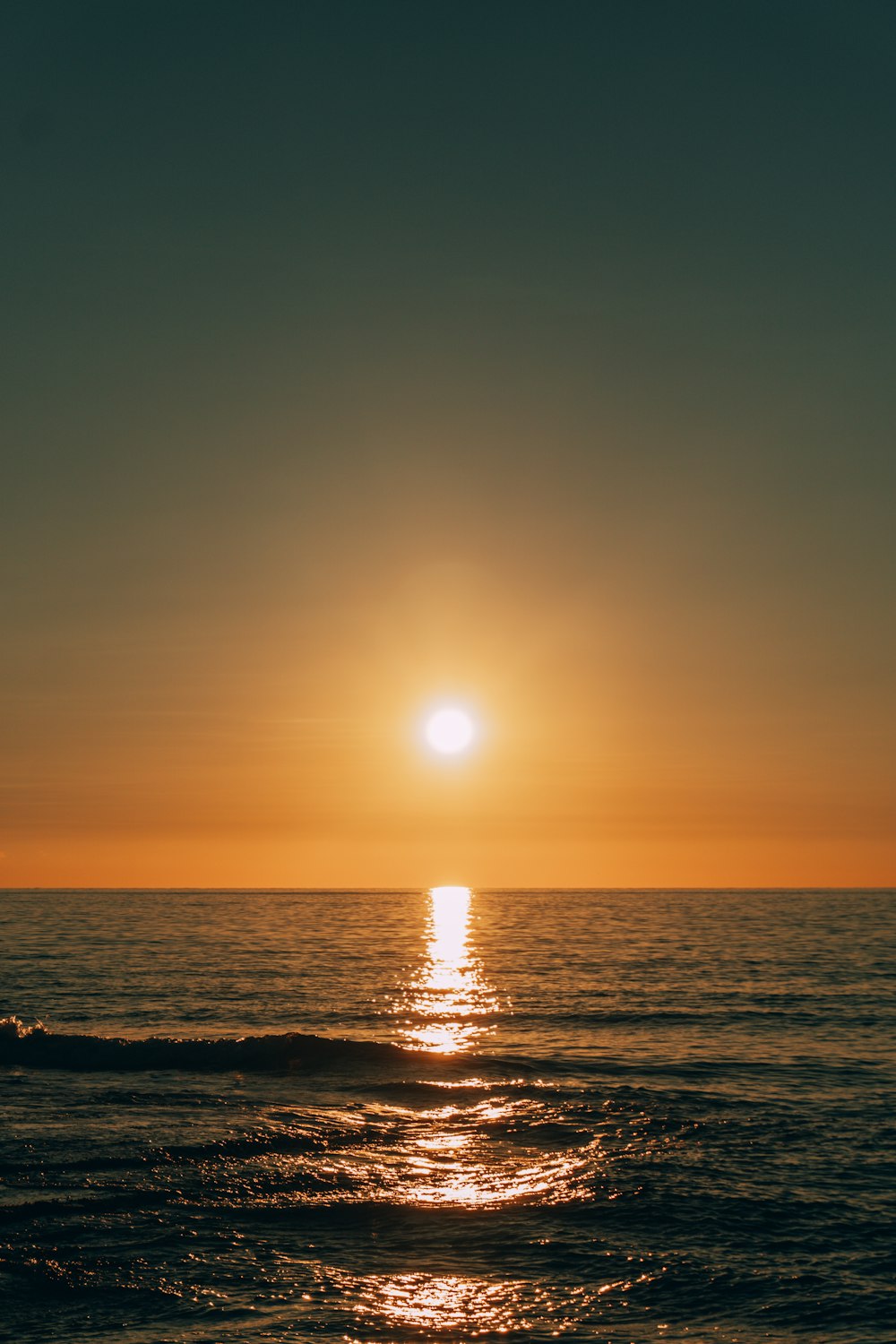 the sun is setting over the ocean on a clear day