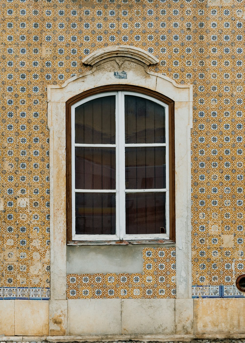 a window on a wall with a tiled pattern