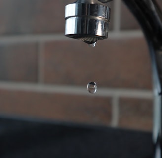 a faucet with a water drop hanging from it