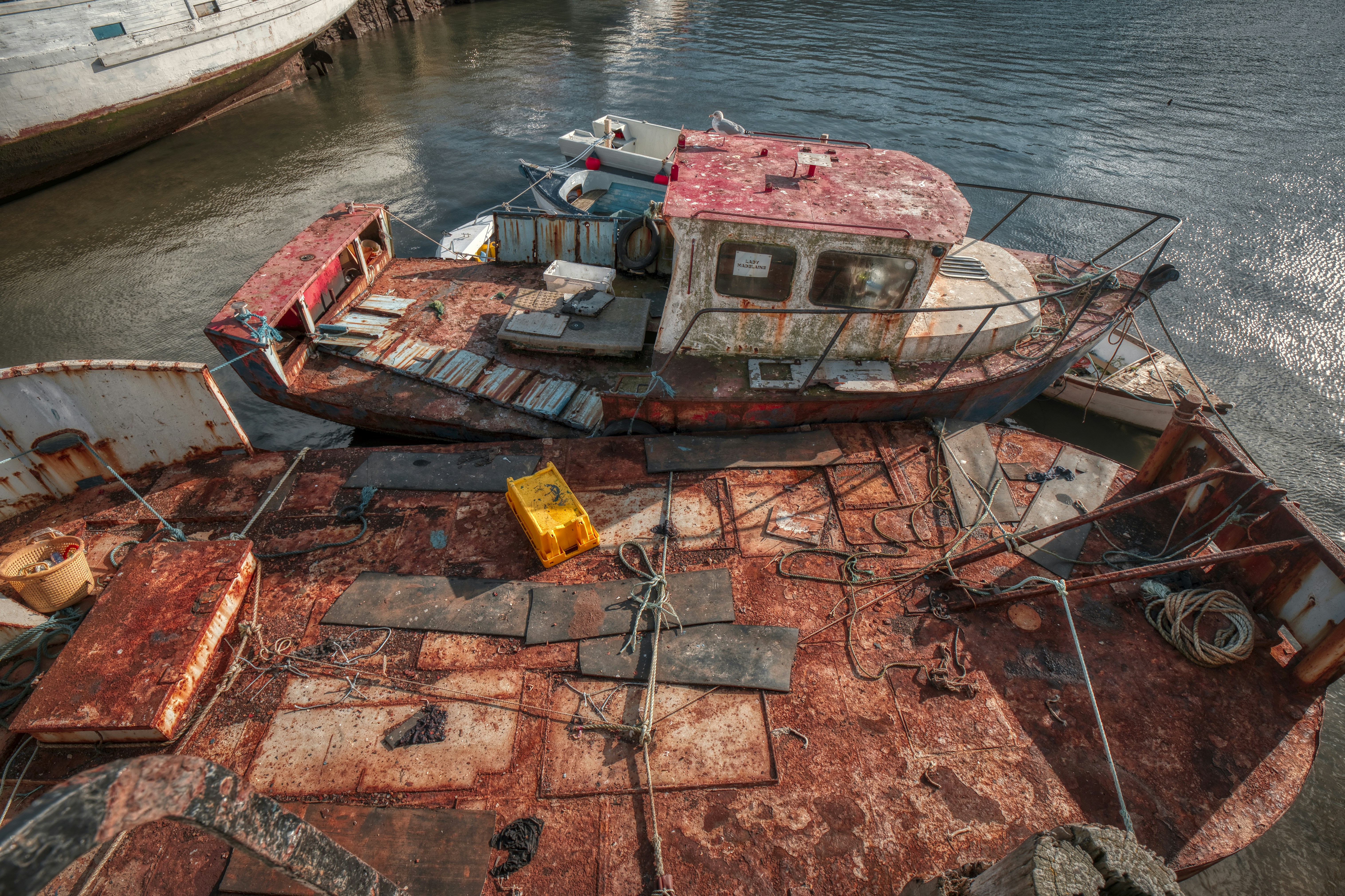 a rusted out boat sitting on top of a body of water