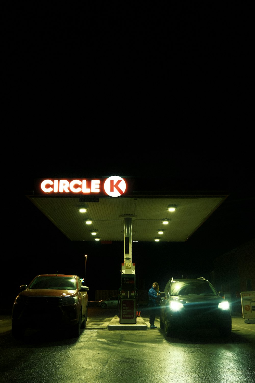 a couple of cars parked in front of a gas station