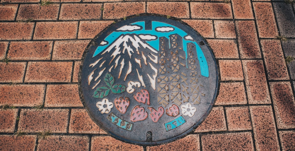 a manhole cover with a picture of a mountain