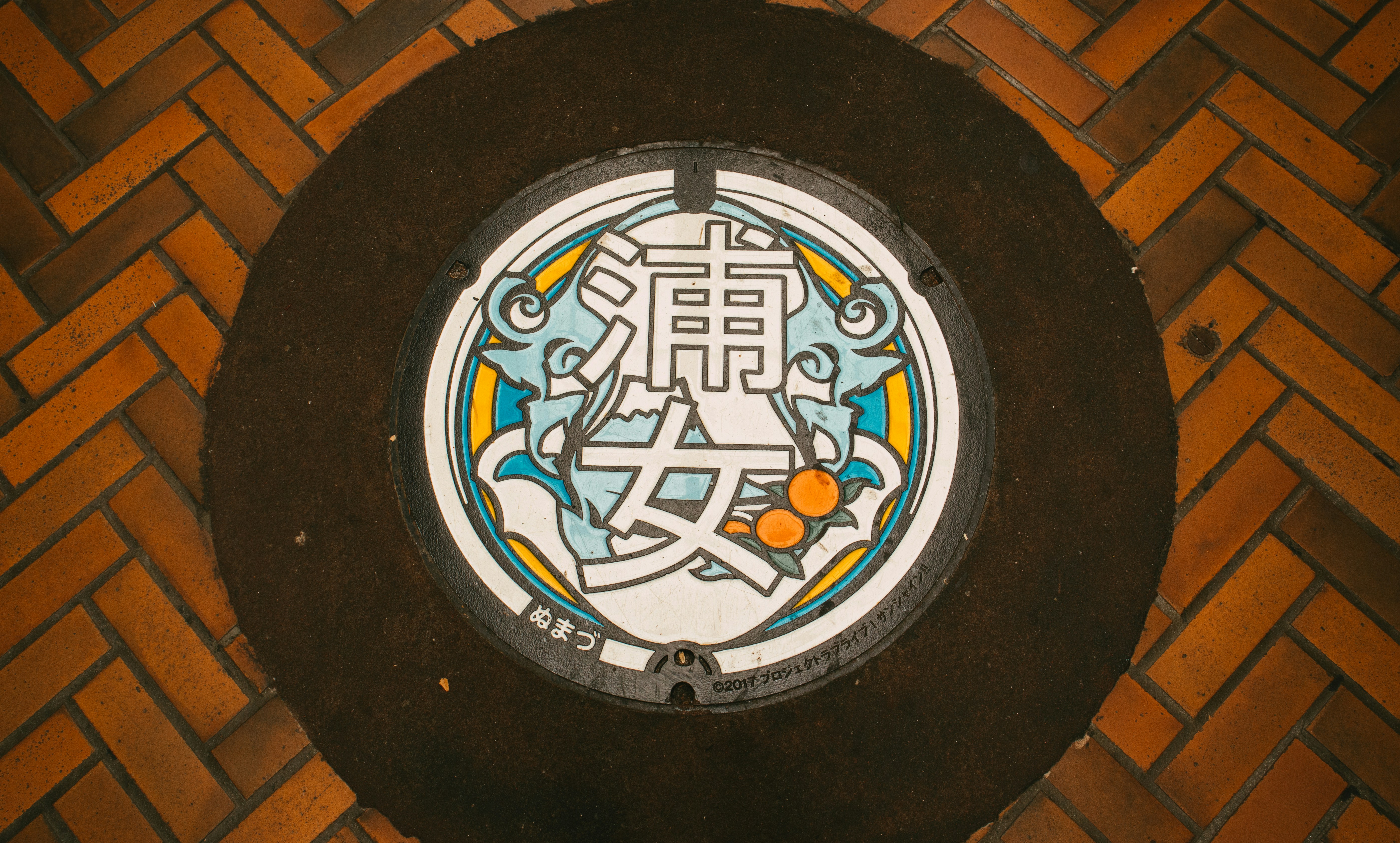 July 2021, Numazu. Colored manhole with anime related design.