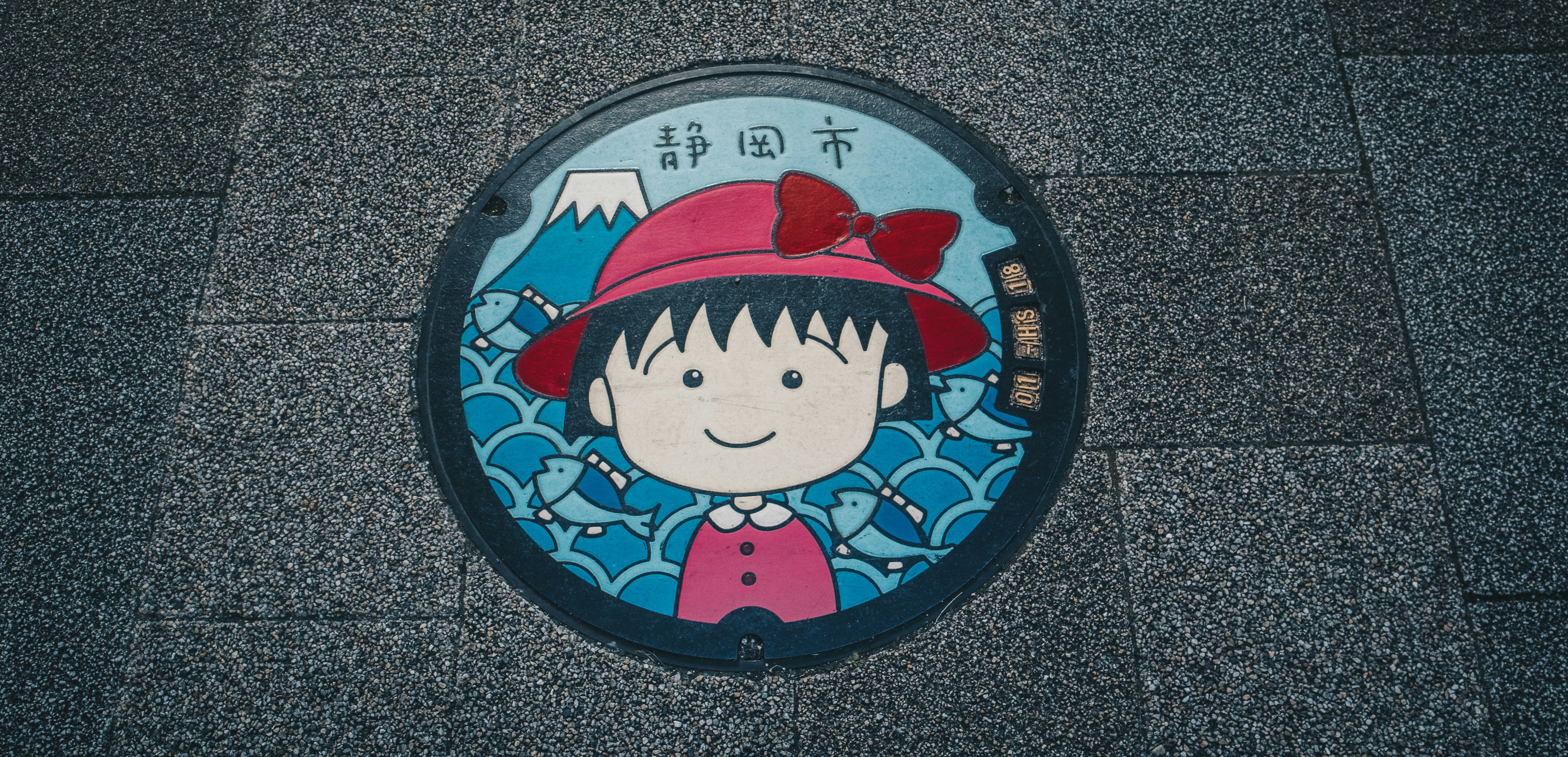 August 2021, Shizuoka. Colored manhole with Chibi Maruko-chan design which is also featured on the designated manhole card.