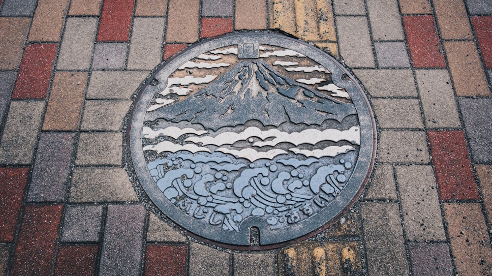 a manhole cover with a picture of a mountain