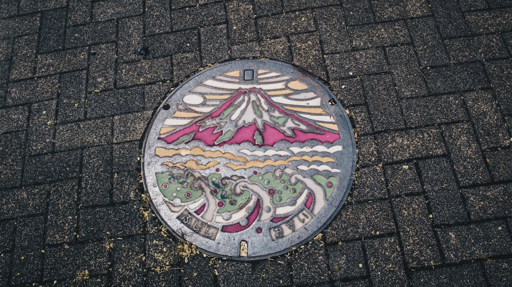 a manhole cover with a picture of a mountain on it