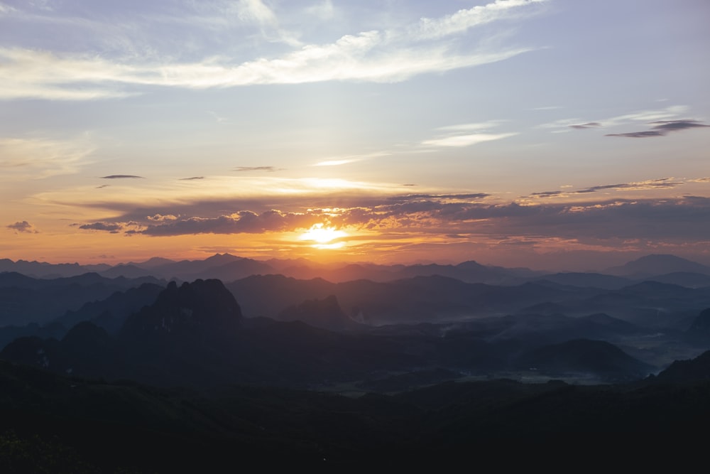 the sun is setting over a mountain range