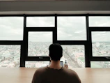 A candid shot of a lawyer reviewing case files at a desk with Karachi cityscape visible through the window.