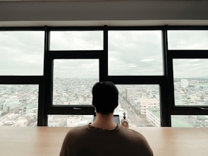 A friendly team member reviewing documents with a city skyline visible through the office window.