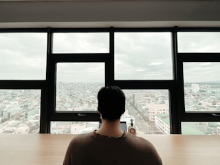 A consultant advising a student over paperwork with a London cityscape in the background.