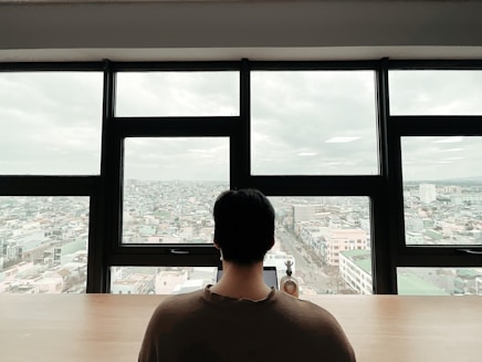 A confident professional reviewing financial reports in a cozy office with New England cityscape visible through the window.