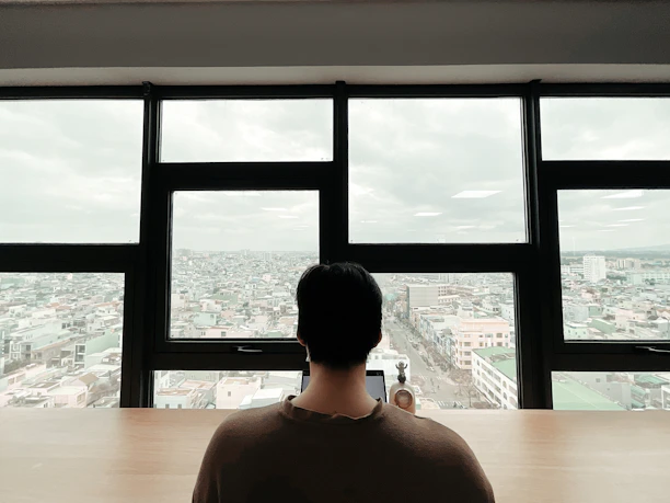 A professional translator working at a sleek desk with Lisbon cityscape visible through the window.