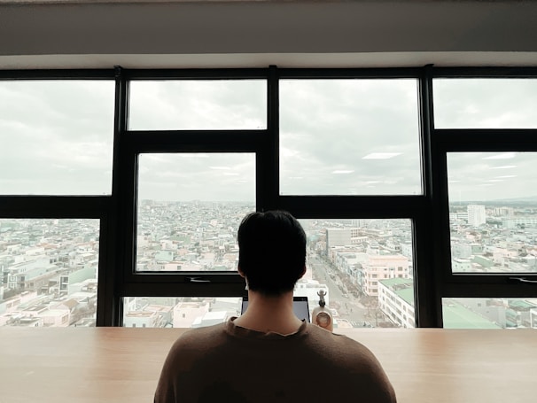 A confident professional reviewing financial reports in a cozy office with New England cityscape visible through the window.
