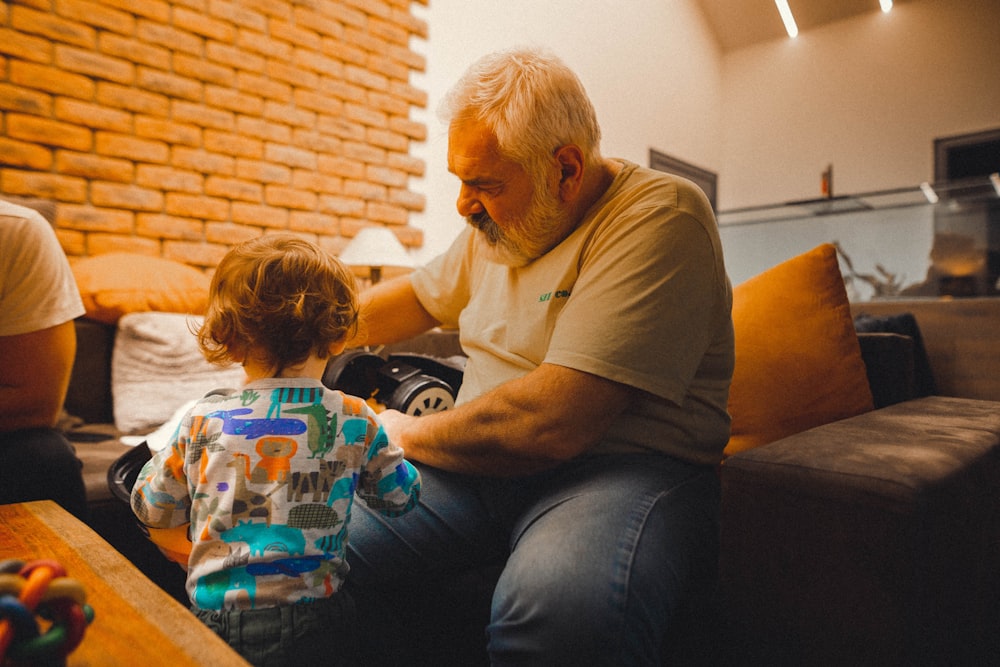 a man sitting on a couch with a child