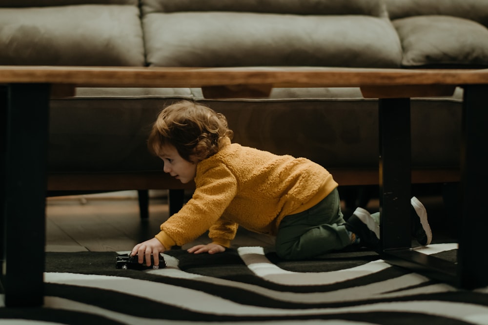 a small child playing with a laptop on the floor