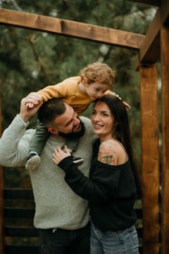 a man and woman holding a small child in their arms