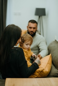 a man and woman sitting on a couch with a child